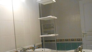 Ein Badezimmer mit zwei Waschbecken, einem Spiegel und einem Handtuchhalter.