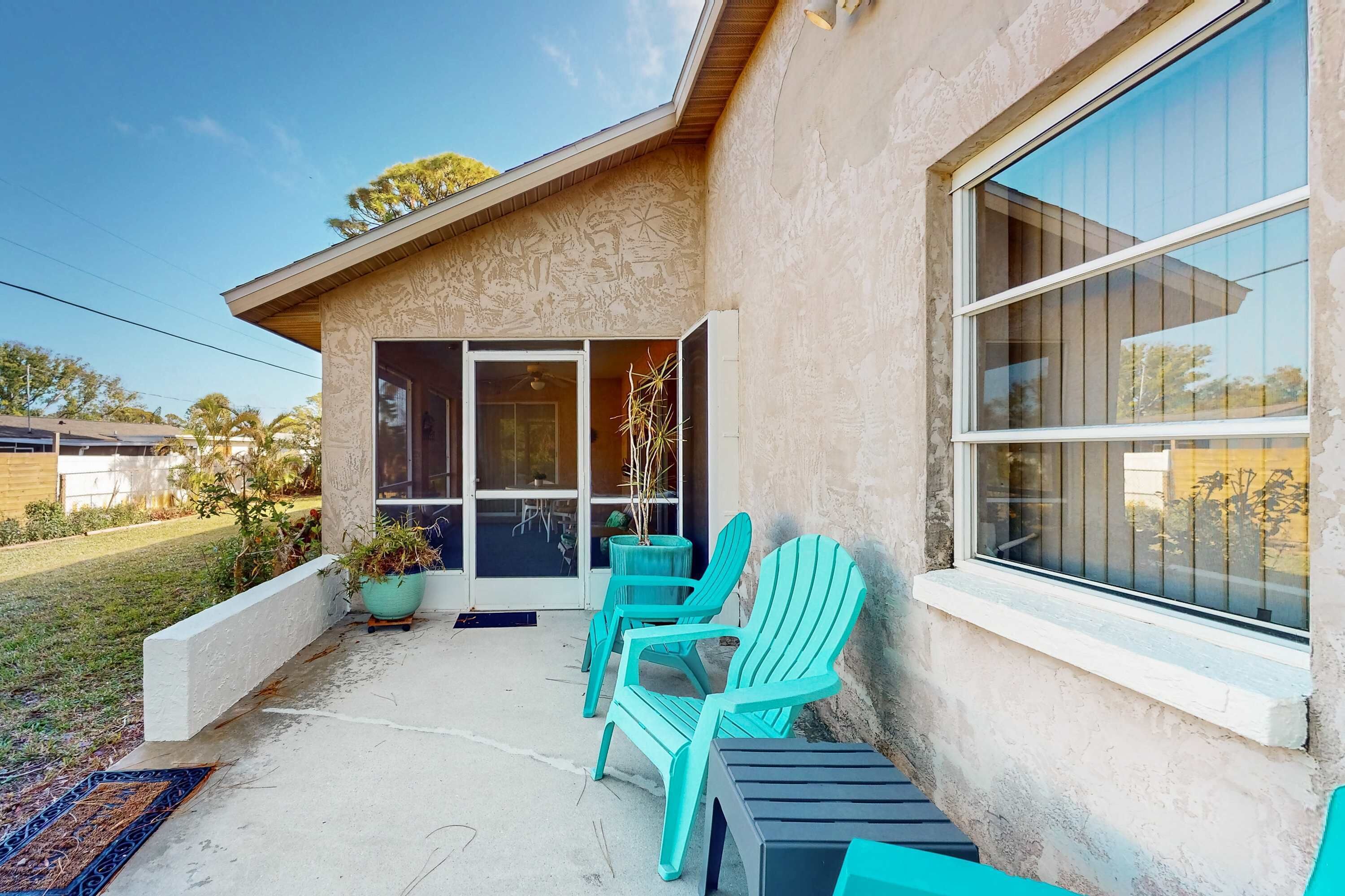 A patio with outdoor seating, a sliding glass door, and a view of the surrounding area.