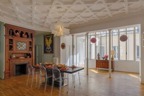 Ein Essbereich mit Holzschrank, Buntglasfenster und Blick durch große Fenster.