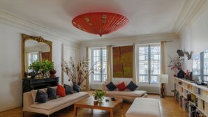 A spacious living room with a sofa, coffee table, and a bookshelf. - Paris Opera Prestige residence (Paris)
