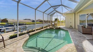 Una piscina techada con vista a un canal y casas al fondo.