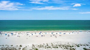 Ein Strand mit weißem Sand und blauem Himmel.