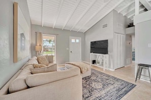 A living room with a sofa, TV, and a fireplace. - Updated tropical home with a private patio, beach gear, AC, and washer/dryer (Marco Island)
