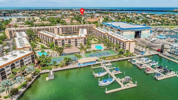 Un port de plaisance avec des bateaux, une piscine et un hôtel composé de plusieurs bâtiments.