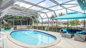 Ein überdachter Pool mit Liegestühlen und einer Sitzecke.