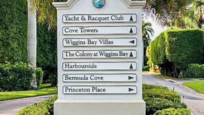 Een richtingsbord met pijlen die wijzen naar verschillende bestemmingen, zoals Yacht & Racquet Club, Cove Towers en Princeton Place.
