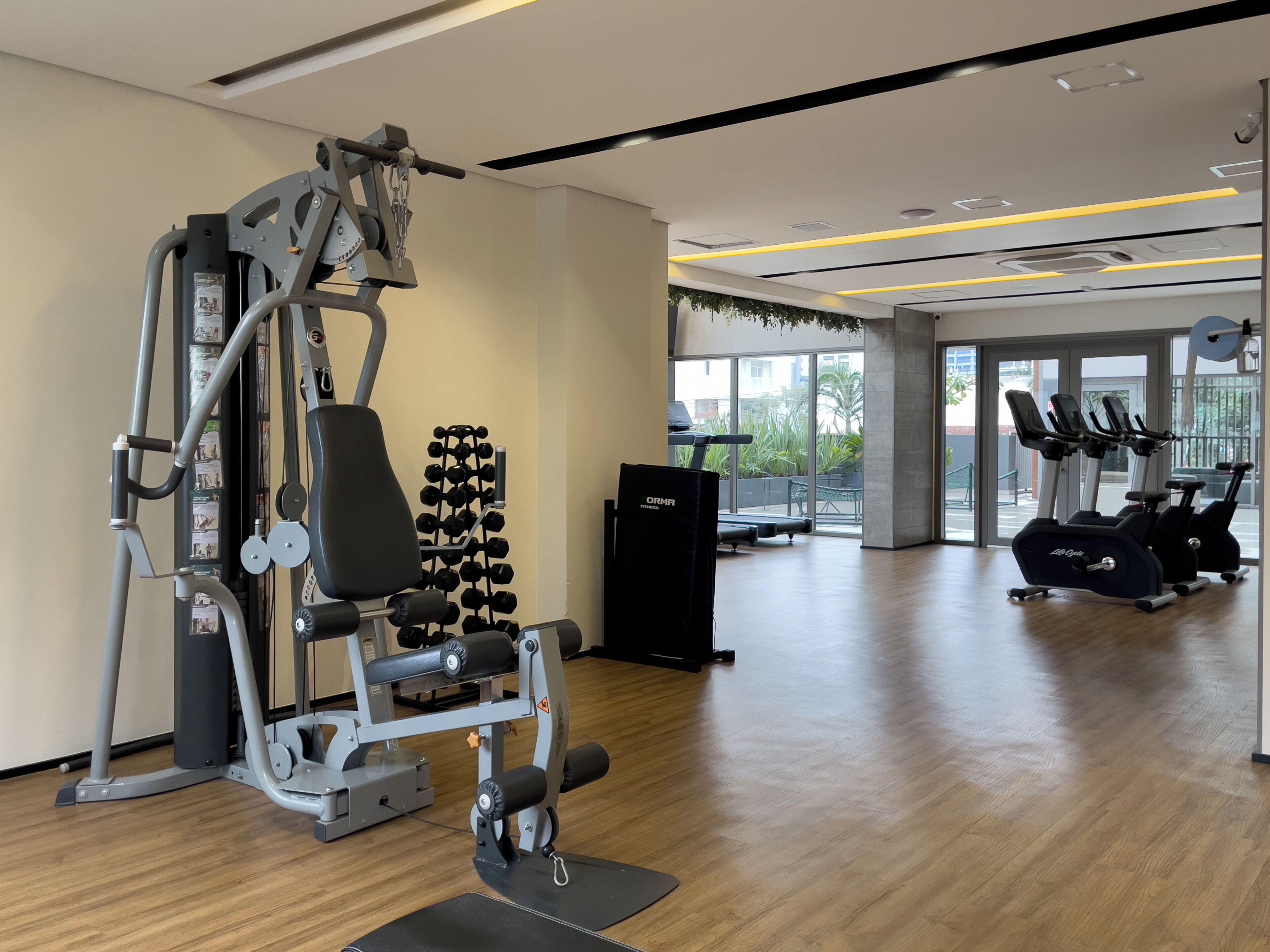A gym with exercise equipment, a treadmill, and a view of the outdoors.