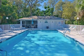 A rectangular swimming pool with a white building in the background, surrounded by trees and a white fence. - 3rd-floor snowbird-friendly condo with enclosed balcony, outdoor pool, W/D, AC (Naples)
