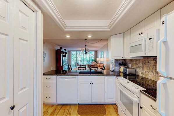 A kitchen with white cabinets, a microwave, an oven, and a dishwasher. - 3rd-floor snowbird-friendly condo with enclosed balcony, outdoor pool, W/D, AC (Naples)