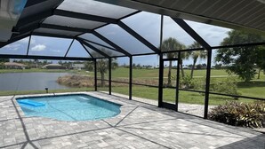 Una piscina scoperta coperta con vista su un lago e del verde.