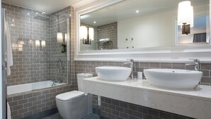 A modern bathroom with a large mirror, two sinks, a bathtub, and a toilet. - Ivanhoe Hotel (Belfast)