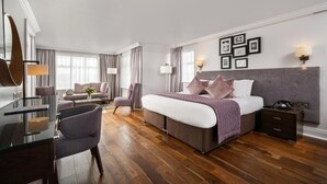 A modern hotel room with a large bed, a desk, a chair, and a sofa. - Ivanhoe Hotel (Belfast)