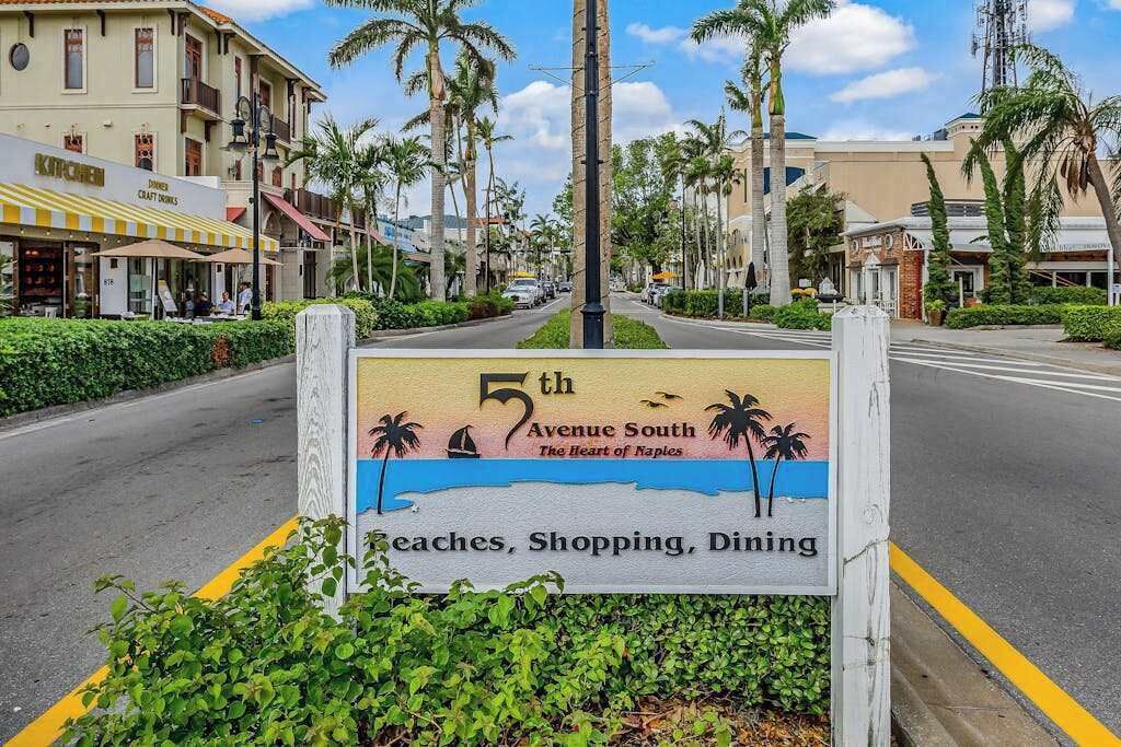Un panneau de signalisation indiquant la 5e Avenue Sud, et précisant qu’il s’agit du cœur de Naples, avec des attractions telles que des plages, des boutiques et des restaurants.