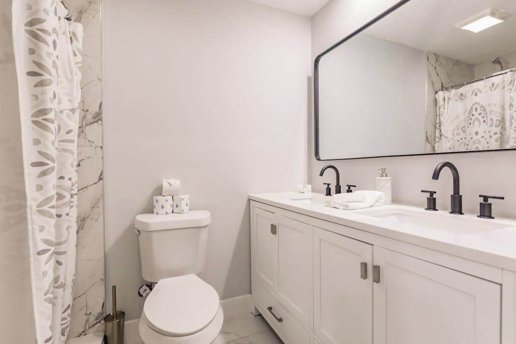 A modern bathroom with a toilet, sink, and cabinet.