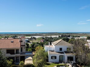 Ein Wohngebiet mit Häusern mit roten Ziegeldächern, blauem Himmel und weiter Aussicht auf das Meer.