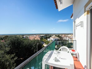 A balcony with a table set for two, overlooking a coastal landscape. - Elymus Apartment, Tavira, Algarve (Tavira)