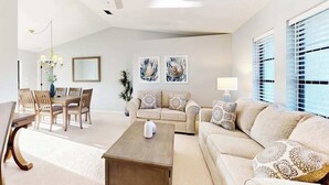 A living room with a dining area, a ceiling fan, and artwork on the walls. - Snowbird Friendly Waterfront Escape with Private Pool, Dock & Serene Canal Views (Port Charlotte)