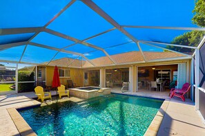 Ein Pool mit Glasveranda, gelben Stühlen und einem Whirlpool.