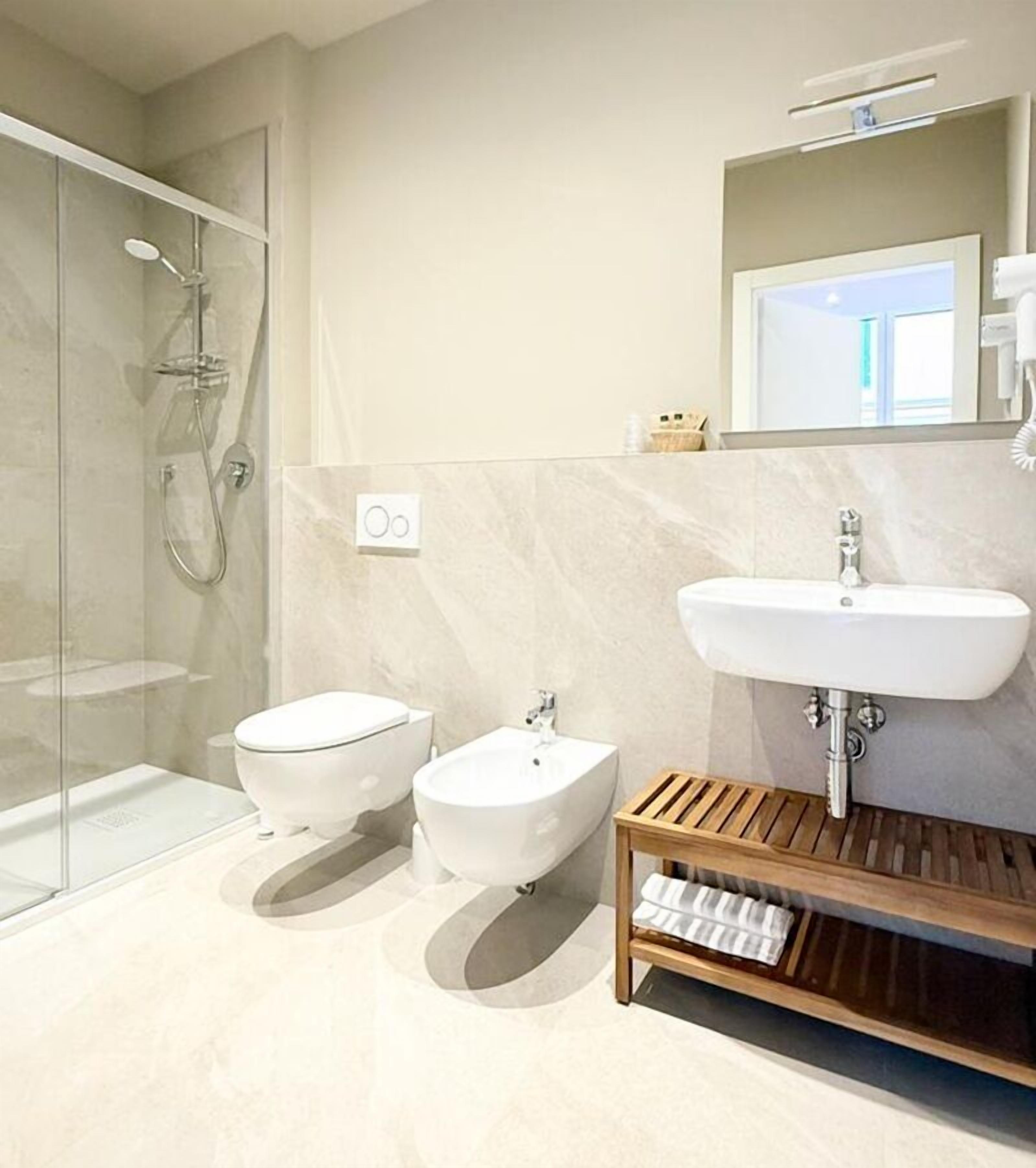 Driepersoonskamer | Badkamer | Een haardroger, handdoeken, zeep, shampoo