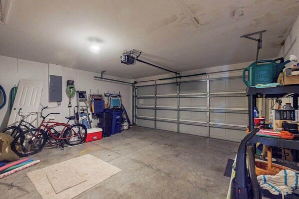 Ett garage med cyklar, en projektor och en arbetsbänk med verktyg.