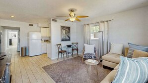 A compact living space with a kitchenette, a dining area, a sofa, and a ceiling fan. - Spacious master duplex w full kitchen, close to beach & shopping (Naples)