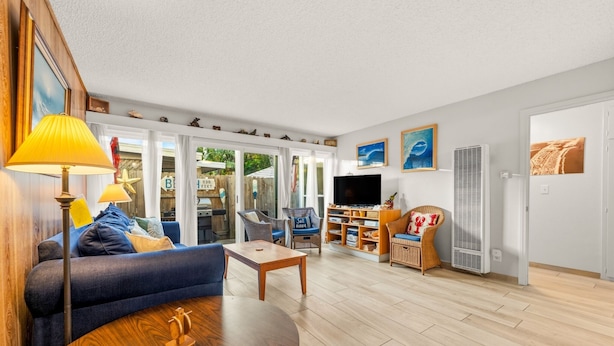A living room with a sofa, coffee table, TV, and wicker chairs. - 25% Off Sept WkDays Great 4 Families, Walk 2 Beach (Ventura)