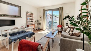 Un salon moderne doté d’un téléviseur à écran plat, d’une table à manger, d’un canapé et d’un balcon offrant une vue agréable.