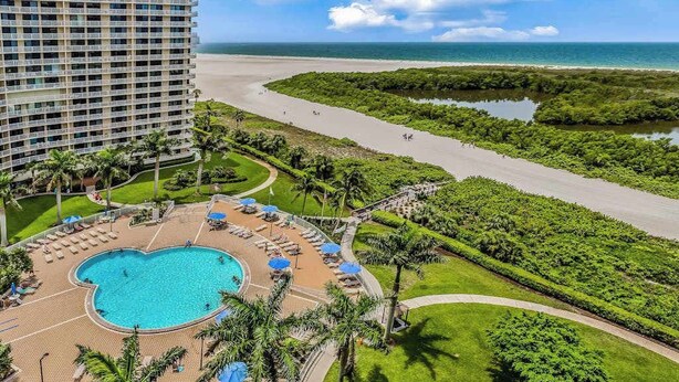 Ein Hotel mit großem Pool, Strand und Blick auf den Ozean.