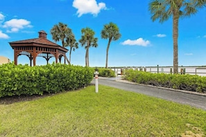 A gazebo, palm trees, and a well-maintained lawn. - Spacious condo with water views, tennis, hot tub & pool - ideal for relaxation (Marco Island)