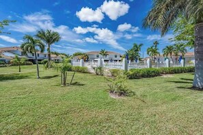 Zona residencial con casas, cerca blanca y palmeras.