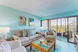 A living room with a sofa, armchairs, a coffee table, and artwork on the wall. - Snowbird-friendly condo with hot tub, outdoor pool, tennis, dock, BBQ, & balcony (Marco Island)