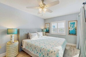 A bedroom with a bed, a ceiling fan, a window with blinds, and two wall-mounted lamps. - Coastal condo with shared pool, tennis court, and washer & dryer (Fort Myers Beach)