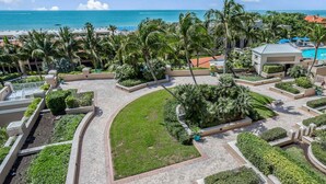 A resort with a pool, palm trees, and a view of the ocean. - Gulf-front condo with pool, hot tub, & central AC - snowbird-friendly (Marco Island)