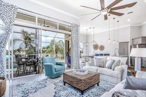 Ein modernes Wohnzimmer mit Deckenventilator, Couchtisch und Sofa.