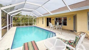 Una piscina coperta con un'involucro in vetro, area relax all'aperto e un edificio giallo.