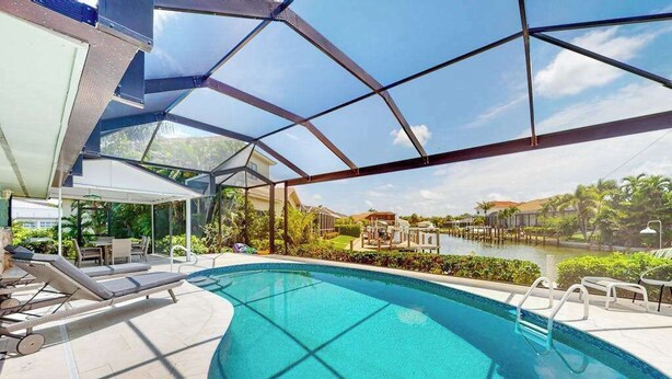 Ein Pool mit Liegestühlen, einer Glaskuppel und Blick auf eine Wohngegend.