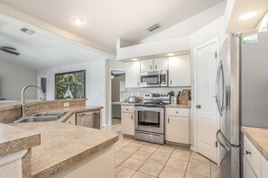 A modern kitchen with stainless steel appliances, a built-in oven, and a microwave. - Dog-friendly home with private heated pool, grill, A/C, & washer/dryer (Port Charlotte)