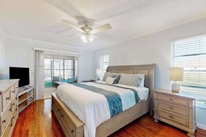 Ein Schlafzimmer mit einem Bett, einem Fernseher, einem Schreibtisch und einem Fenster.
