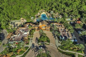 An aerial view of a resort with a central building, multiple guest rooms, a swimming pool, and lush greenery. - Elegant villa with private lanai, desk, resort pool, spa & washer/dryer (Naples)