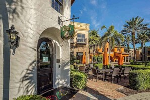 A building with a sign reading 'The Pub,' outdoor seating with umbrellas, and palm trees. - Elegant villa with private lanai, desk, resort pool, spa & washer/dryer (Naples)