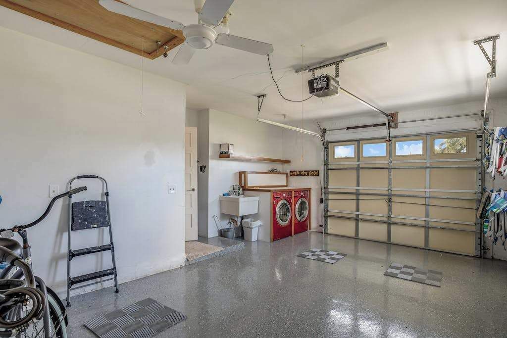 Eine Garage mit Waschmaschine, Fahrrad und Deckenventilator.