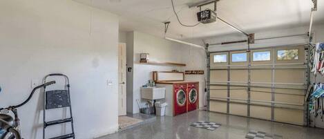 Eine Garage mit Waschmaschine, Fahrrad und Deckenventilator.