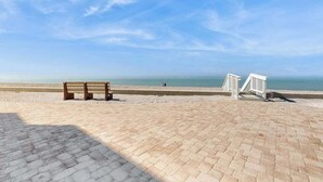 A paved beach area with a wooden bench and a white railing. - Dog-friendly home w/access to Englewood Beach, WIFI, and outdoor patio (Englewood)