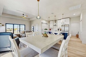 A modern kitchen with white cabinets, a dining table, and a ceiling fan. - Placida at Meadows & Villas; brand-new duplex, dogs OK, golf courses nearby (Placida)