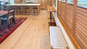 A spacious kitchen with wooden cabinets, a central island, and a large window with blinds. - Camp Ridgewood- Spacious 6-bedroom house in lovely Bolton Landing with AC (Bolton Landing)
