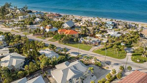 Luftaufnahme einer Küstenwohngegend mit Häusern, Straßen und einem Strand.