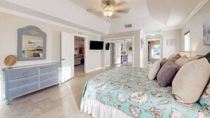 Ein Schlafzimmer mit Bett, Kommode und Fernseher.