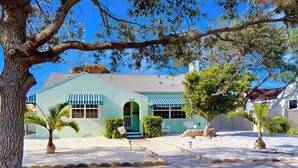 A two-story building with a green facade, a central entrance with a green door, and a small porch area. - Dog-friendly duplex with outdoor living area - walk to beach/downtown (Venice)