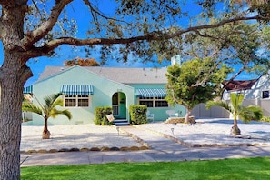 A two-story building with a green facade, a central entrance with a green door, and a small porch area. - Dog-friendly duplex with outdoor living area - walk to beach/downtown (Venice)