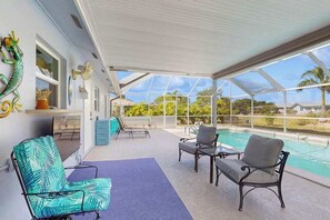 A covered outdoor area with a pool, seating, and a view of the outdoors. - Coastal home with private, saltwater pool, gas grill, and internet (Punta Gorda)
